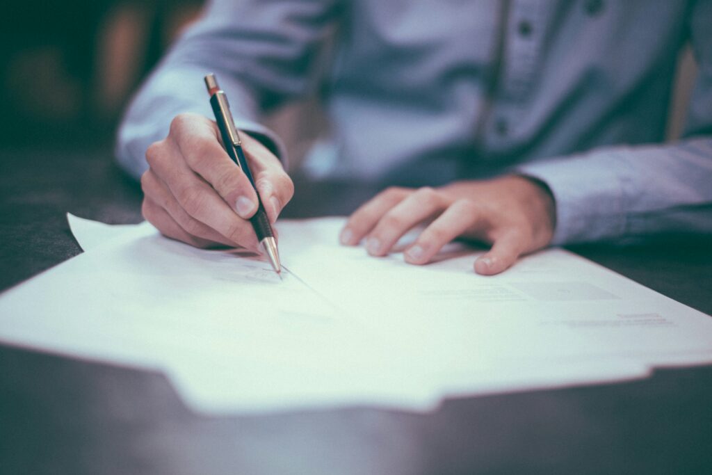 Hands signing documents with pen
