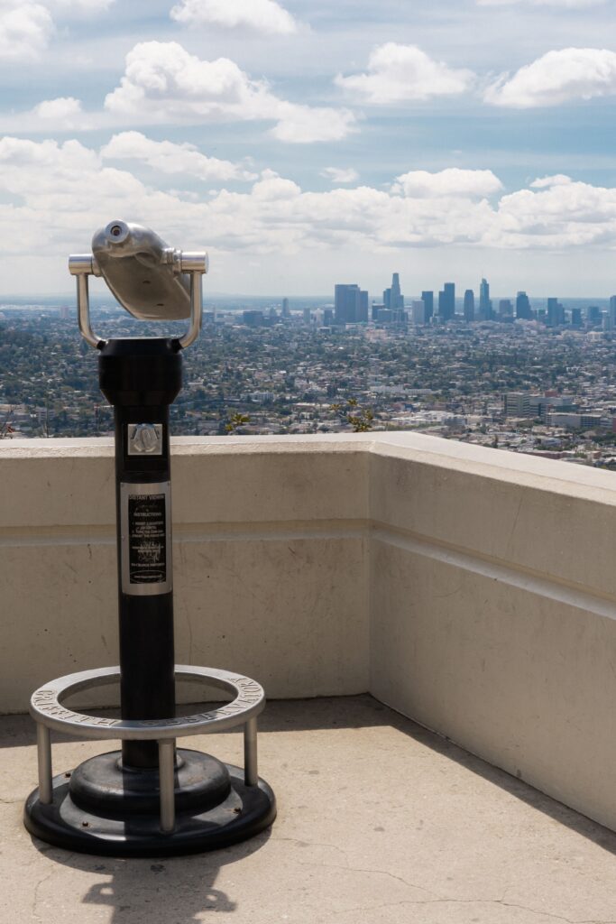 Coin-operated binoculars overlooking city skyline