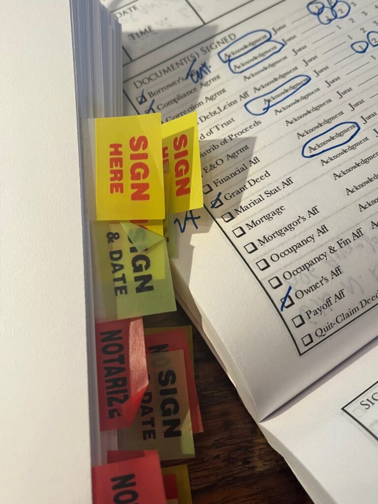 Legal documents with "Sign Here" sticky tabs