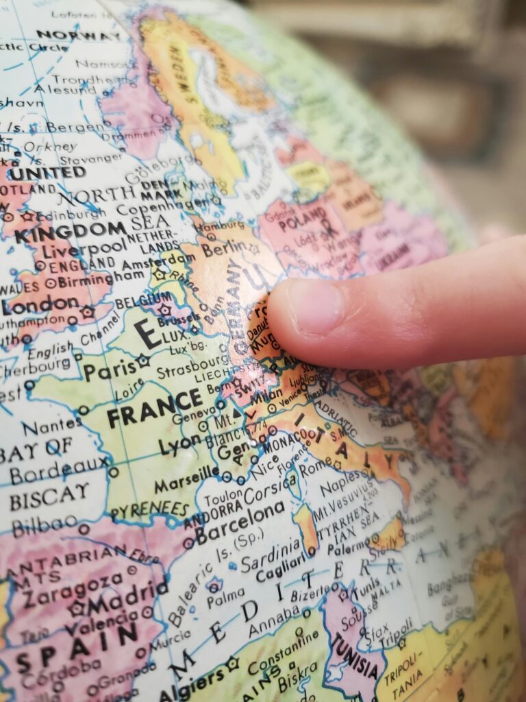 Finger pointing at Europe on a globe