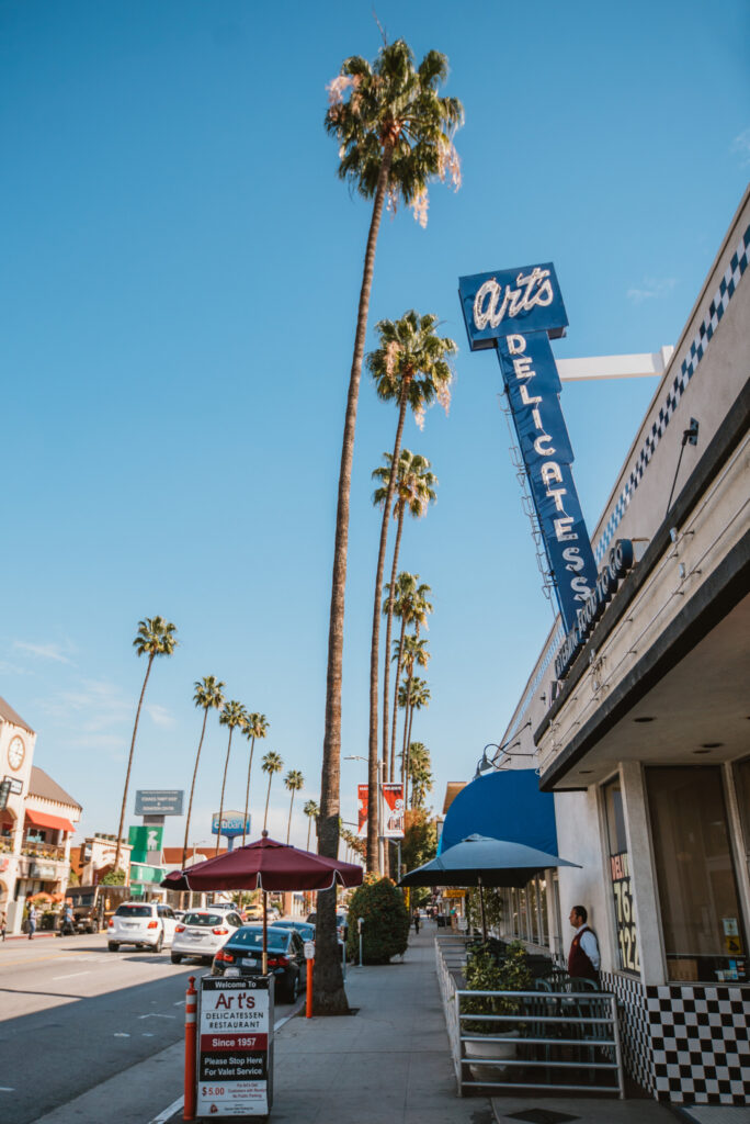 Street with palms and Art's Delicatessen sign