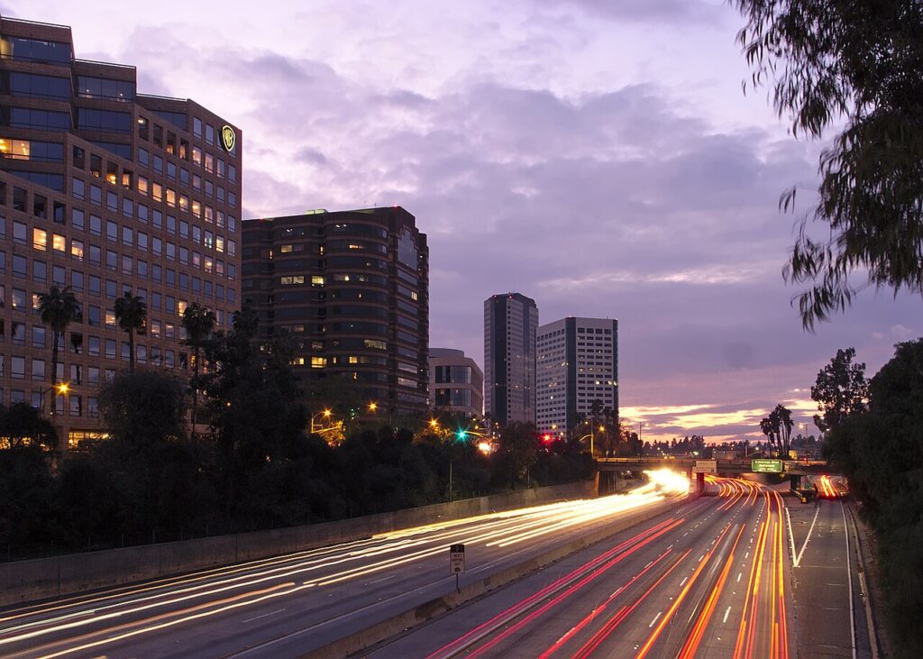 Dusk freeway light trails with city skyline