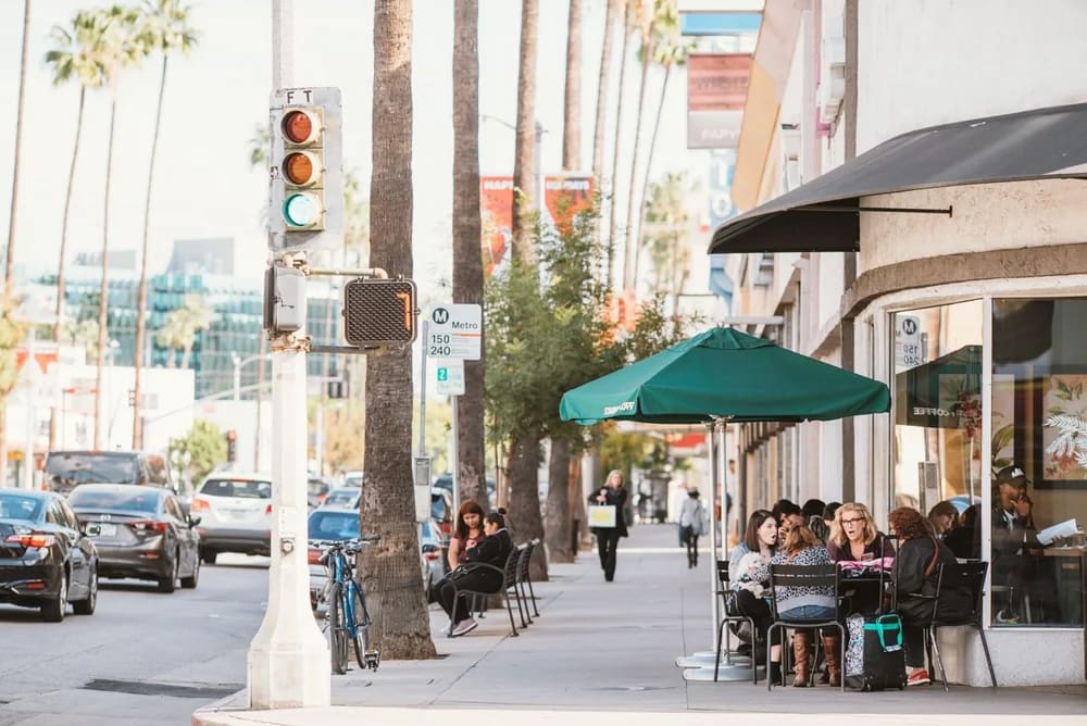 Outdoor sidewalk cafe with diners under umbrella